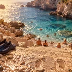 Plage de la mala : escaliers vers la crique et galets mouillés